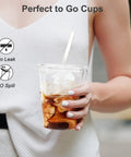 Person holding 100 Pack 16 Oz Clear Plastic Cups With Lids And Straws, Sturdy Food Safe Disposable Cups For Iced Coffee, Smoothies And Cold Drinks