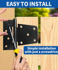 Installing heavy duty black gate hinge 3.5 inch with screws on wooden fence, shown with screwdriver in hand