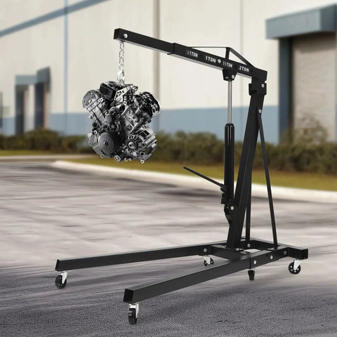 Built Like A Tank 2 Ton Folding Engine Hoist Crane with six swivel casters lifting an engine in a garage setting.