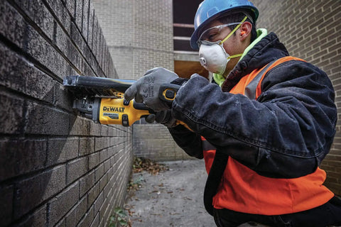 Worker using 60V Max Brushless Cordless Grinder With Kickback Brake Four And A Half Inch To Six Inch Wheel 9,000 RPM No Load Speed High Power Tool Only Renewed For Metal Fabrication And DIY Projects on brick wall.