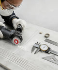 A worker using a grinder with Badass Grade 4 Pack Mini Diamond Saw Blades Set For Granite Marble And Tile Precision Cutting.