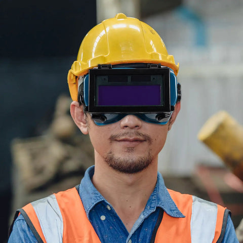 Boss Grade Auto Darkening Welding Goggles Heavy Duty Industrial Safety Glasses With Lightning Shade Switch For Grinding Soldering And Precision Steel Fabrication In Navy Blue worn by a worker with a yellow hard hat.