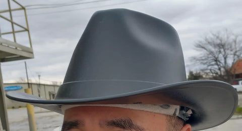 Close-up of Vulcan Cowboy Style Hard Hat With Six Point Deluxe Nylon Ratchet Suspension And Front Cotton Sweatband, worn outdoors.