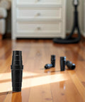 Black ABS vacuum cleaner hose adapter standing upright on wooden floor; extra connectors visible in background.