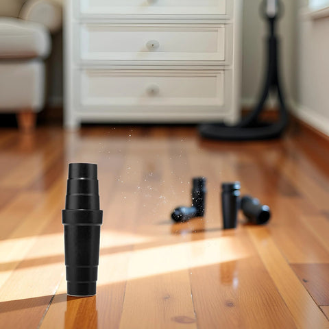 Black ABS vacuum cleaner hose adapter standing upright on wooden floor; extra connectors visible in background.