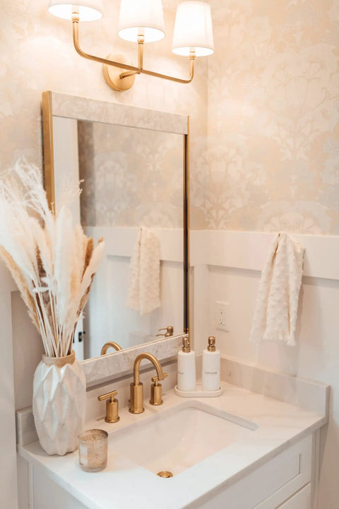 Dawson White Fabric Stay-Straight Shade Bath Vanity Light in Aged Brass above bathroom mirror and sink