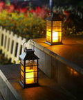 Two Pack Lit Solar Powered Outdoor Hanging Lanterns With Waterproof LED Flickering Flameless Candles on stone steps at night