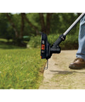 40V Max Cordless String Trimmer And Edger With Telescoping Pole Two In One Weed Wacker For Lawn Care PowerCommand Dial For Maximum Power Or Runtime Battery And Charger Included Lightweight And Easy To Maneuver For Yard Work, in use along a sidewalk edge, showing precision trimming capabilities.