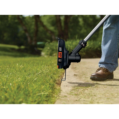 40V Max Cordless String Trimmer And Edger With Telescoping Pole Two In One Weed Wacker For Lawn Care PowerCommand Dial For Maximum Power Or Runtime Battery And Charger Included Lightweight And Easy To Maneuver For Yard Work, in use along a sidewalk edge, showing precision trimming capabilities.