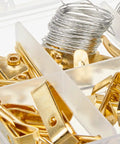 Close-up of DIY Picture Hanging Hardware Kit 220 Piece Brass Finish Set with wire, hooks, and brass hangers in a box.