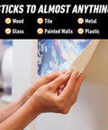 Person using Natural Tan Mounting Putty For Posters And Photos, 84 Pre-Cut Squares Per Pack, Pack Of 3, Non-Toxic, Removable