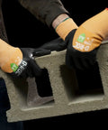 Two hands wearing D Roc ANSI A4 Cut Protection Oil And Liquid Absorbing TriTek Work Gloves With DX Technology, lifting cinder block