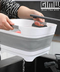 Person using 2.6 Gallon Collapsible Wash Basin With Drain Plug For Baby Bottles And Dishes over sink