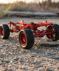 12-Scale RC Aluminum Alloy Chassis Kit For DIY Electric Car Build on rocky terrain with sturdy black frame and red wheels