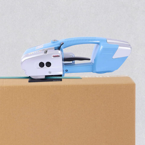 Heavy Duty Electric Rechargeable PET PP Strapping Tool 3 In 1 Bander on cardboard box for quick packaging.