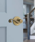 Lido Entry Door Lever With SmartKey Re-Key Security, Antique Brass Finish on door, reversible handle visible
