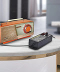 Adjustable DC Power Supply 3A 72W 3V To 24V Output Universal Switching Adapter on table near vintage radio