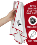 Hand holding a white cloth with red trim from the Large Microfiber Polishing Cloths for Glassware 2 Pack White and Gray Streak Free Lint Free Shine and Clarity for Wine Glasses and Stemware Extra Large Design for Quick Mirror Like Finish.