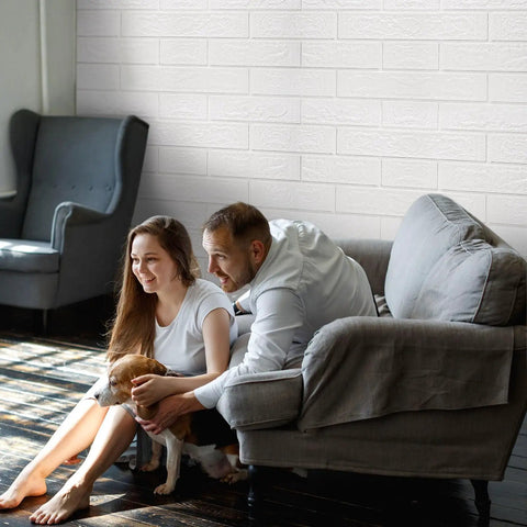 Couple and dog in room with 3D Wall Panels Peel And Stick Waterproof Faux Stone Self Adhesive 20 Pack In Rock Black accent wall.