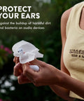 White audio hearing-aid cleaning towelette used on a white wireless earbud