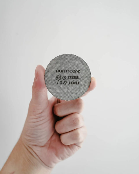 Hand holding Espresso Puck Screen For 54mm Portafilter Lower Shower Screen 53.3mm Fit 316 Stainless Steel 1.7mm Thick 150 Micron Layer