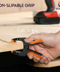 WOCTEC 6-inch plastic spring clamp, black with orange grips, side view holding plywood edge