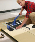 Man using 24 Inch Manual Tile Cutter With Tungsten Alloy Wheel And Double Rail Track for ceramic tile cutting on the floor.
