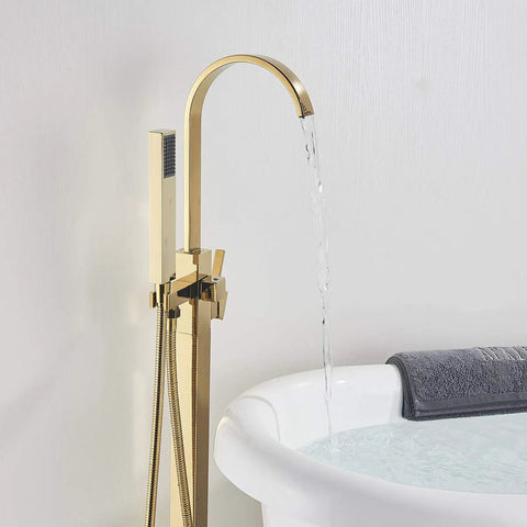 Solid Brass Freestanding Bathtub Faucet With Hand Shower in Gold Polished Finish, next to filled bathtub, water flowing, floor mount