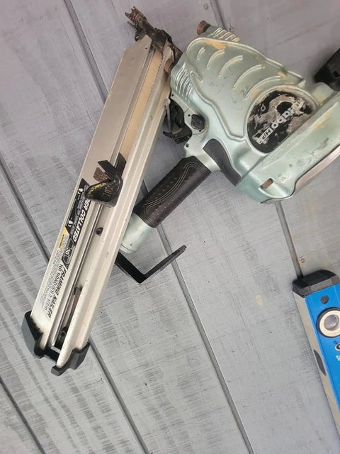 Steel Pneumatic Rafter Hook Hanger With One Quarter Inch Air Tool Swivel Fitting on a framing nailer against a wooden surface