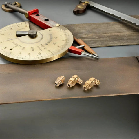 Top Tier 9 Piece Copper Grease Fitting Kit For Cars And Heavy Excavators With M8 Threaded Nipples Precision Engineered For Maximum Durability And Seamless Hydraulic Performance In Golden Finish Plus Caps Included. Three brass grease fittings on a metal surface