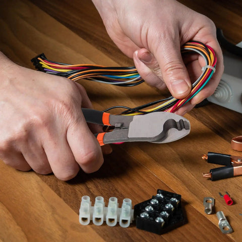 Dang Tough Lightweight Wire Strippers And Cutting Pliers Featuring Slick Ergonomic Rubber Grips and Rock Solid Steel Build for Seasoned Trade Electricians and Contractors cutting colorful electrical wires.