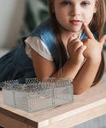 Slick Light Gray Plastic Miniature Fence Kit With Dead Simple Snap Together Design For Farm Diorama And Prison Model Builds A Top Notch Diy Playset That Snaps Right In Around Minis And Blocks For Rad Build Moments on a wooden table with a child.