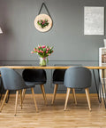 No Fuss Nail On Furniture Glides 60 Piece Set on a wooden dining table with gray chairs and flowers.