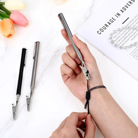 Person using stainless steel alligator clips set with telescopic wire clamps and pen clip for bracelet making on wrist.