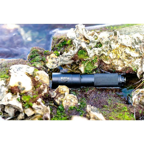 1300 Lumen Narrow Beam Dive Light with Tail Switch nestled among rocks, demonstrating snorkel and dive use, 10 degree beam focus.