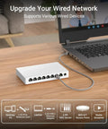 2.5Gbps 8 Port Unmanaged Ethernet Switch For Gaming And Home Networking, connected to a laptop on a wooden desk.