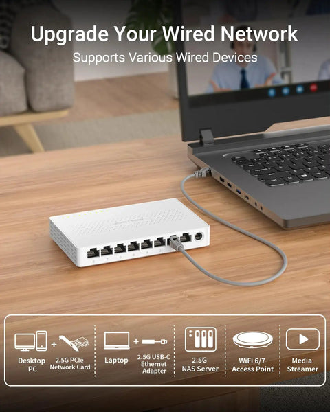 2.5Gbps 8 Port Unmanaged Ethernet Switch For Gaming And Home Networking, connected to a laptop on a wooden desk.