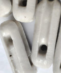 Close-up of Glazed Ceramic Antenna Insulators, 22 Pack, Small Ceramic Isolators for Dipole with glazed finish and hole.