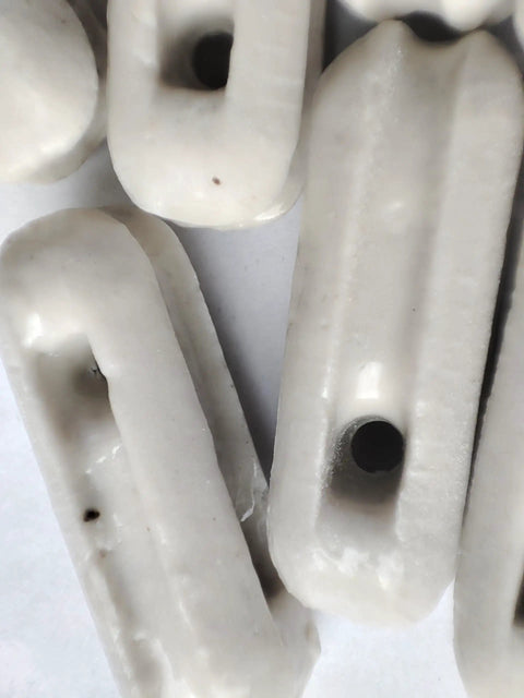 Close-up of Glazed Ceramic Antenna Insulators, 22 Pack, Small Ceramic Isolators for Dipole with glazed finish and hole.