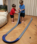 Kids playing with Flexible Dual Lane Race Track Set With U Turn Design For Kids 13 Feet Of Track Length DIY Curves To Build Unique Turns Two Lanes For Side By Side And Overtake Fun Compatible With 1 To 64 Scale Diecast Cars on wooden floor