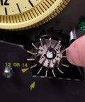 Close-up of a mechanical irrigation timer switch for 125V systems with rain sensor enabled, showing adjustment mechanism.