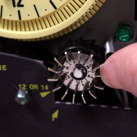 Close-up of a mechanical irrigation timer switch for 125V systems with rain sensor enabled, showing adjustment mechanism.
