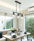 Three Light Farmhouse Kitchen Island Pendant Chandelier, 35.4 in Long, Black Finish With Seeded Bubble Glass above dining table.