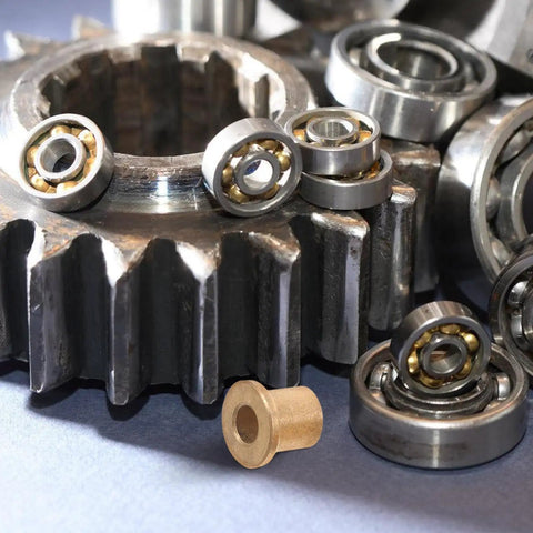 Image of Six Piece Flanged Copper Sleeve Bearings With Step Shoulder Flange And Wrapped Brass Bushings next to gears and ball bearings.