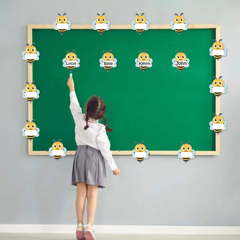Child pointing at Bee Cutouts For Classroom Decorations 50 Pack Name Tags And Desk Nameplates Cute Bee Style Labels on bulletin board.