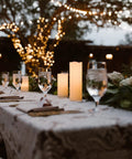 Set Of Nine Ivory Real Wax Flameless Pillar Candles Battery Operated 4 Inch Through 9 Inch Heights with remote on event table