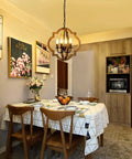 Dining room with Rustic 4 Light Orb Chandelier Handcrafted From Solid Wood With Black Metal Details Ideal For Dining Room Kitchen Island Hallway Or Entryway Delivers Cozy Warm Farmhouse Glow And Modern Farmhouse Charm.