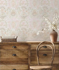 Pink Bohemian Damask Peel And Stick Wallpaper Removable Repositionable Boho Wall Covering For Easy DIY Decor No Glue Needed Mess Free 20.5 In By 16.5 Ft Made In The USA Great For Accent Walls And Furniture Refresh displayed behind a rustic wooden dresser with a vase and wicker basket.