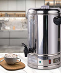 65-Cup Commercial Coffee Urn With 10.5 Qt Capacity, 1250W Stainless Steel Percolator on kitchen counter with coffee cup.