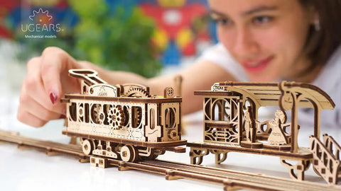 Hands-On Mechanical Tram Line Wooden Model Kit From Town Series, 3D Puzzle Assembly With Realistic Details, Laser-Cut Plywood Build For DIYers, Great Gift For Techies And Craft Fans, woman assembling wooden tram model